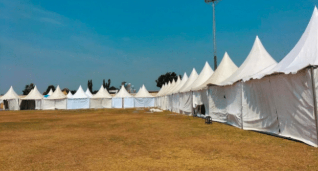 Pop-up tent being assembled securely at an outdoor event with proper anchoring and setup